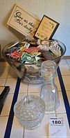 Overall lot showing glass bowl full of magnets, candy dish, cruet, plaques