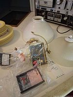 Two ribbed white glass shades, bags containing lamp harps, fixture plates, screws and connectors