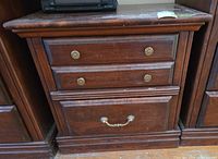 Front view of dark wood nightstand showing both drawers and hardware