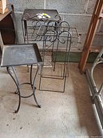 Three metal plant stands on garage floor