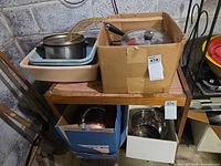 Assorted boxed pots, pans and lids on shelving
