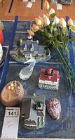 Overview showing lighthouse figurines, glass whale, shell flowers, trinket box and candle