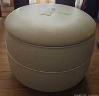 Overall view of ottoman showing shape, color and lid