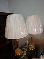 two lamps with shades wrapped in plastic