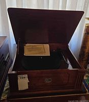 Turntable cabinet open showing platter and certificate