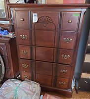 Full view of wooden chest of drawers showing design, hardware and wear