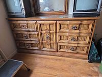 Front view of dresser showing six drawers and ornate pulls