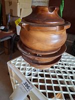 Full view of stacked teak caddy on lattice surface showing overall form and base