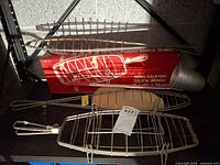 Three wire grill baskets and long handled strainer on shelf