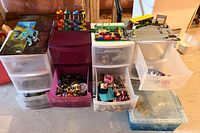 Plastic drawer units filled with loose Lego bricks and partial builds