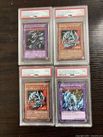 All four PSA-graded Yu-Gi-Oh cards displayed together