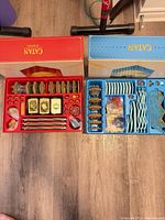 Red Catan 3D Edition box and blue Catan 3D Expansions box opened with all components visible