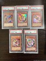 Group shot of five PSA slabbed Dark Magician Girl cards