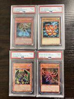 Group shot of four PSA-slabbed Yu-Gi-Oh! cards