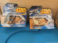 Front view of sealed TIE Fighter and X-Wing blister packs on blue surface