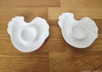 Top view of two hen-shaped egg cups showing form and egg wells