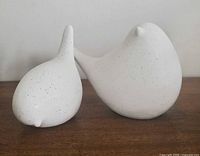 Front view of both ceramic bird sculptures showing size difference and speckled finish