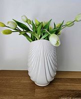 Front view of the white ceramic fan-shell vase with flowers for scale