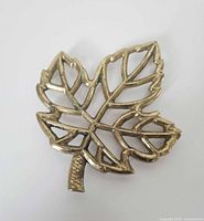 Front view of brass leaf trivet showing openwork design