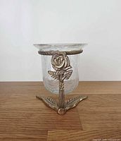 Full view of crackle glass votive holder on brass rose stand