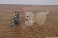 Bronze sitting cat beside onyx crouching cat