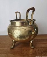 Front view of brass censer showing dragon motif and two handles