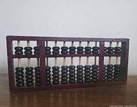 Front view of wood-frame abacus showing beads and divider