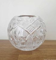 Front view of spherical crystal rose bowl showing pinwheel cuts
