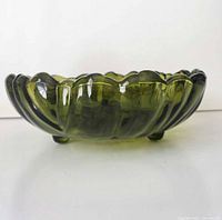 Side profile showing avocado green glass bowl on three feet