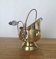 Full view of brass coal scuttle on pedestal base