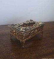 Angled view showing top opening and floral filigree details of tissue box