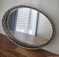 Front view of oval mirrored tray with filigree border