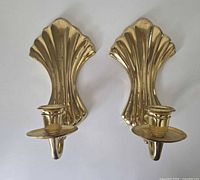 Front view showing both brass scallop shell sconces with candle cups
