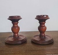 Both turned wood candlestick holders side by side