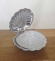 Shell dish open showing silver plate interior and glass insert in place