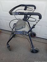 Side view of navy Dolomite Legacy rollator folded, showing handles, brakes, back strap and wheels