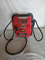 Front view of EverStart 750 Amp jump starter showing clamps, air hose and labels