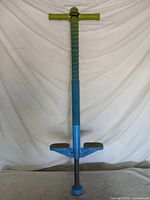 Full view of blue and green Flybar Maverick 2.0 pogo stick standing upright