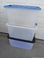 Three stacked plastic totes showing colors and lids