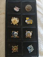 All eight baseball trading pins arranged in tray