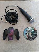 Group shot of Joy-Con Grip, USB microphone and PS3 disc