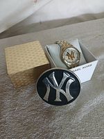Watch in Michael Kors box beside belt buckle showing both items together