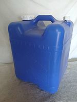 Front view of blue Reliance Aqua-Tainer container showing molded panel and carry handle