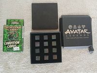 Avatar Legends dice box open showing 12 dice alongside Pathfinder Condition Cards deck