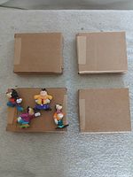 Four PVC figures and four brown mailer boxes grouped