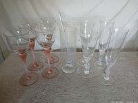 All items grouped: pink stem wine glasses, clear flutes, Bacardi pitcher, stirrer visible