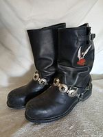 Pair of boots angled view showing harness strap, toe wear, patch