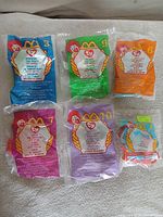 Five sealed Ty Teenie Beanie Baby bags displayed