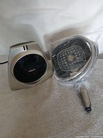 Vornado heater alongside packaged rain shower head, handheld wand and hose