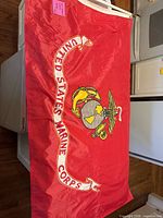 Full view of red USMC flag displaying emblem and scroll